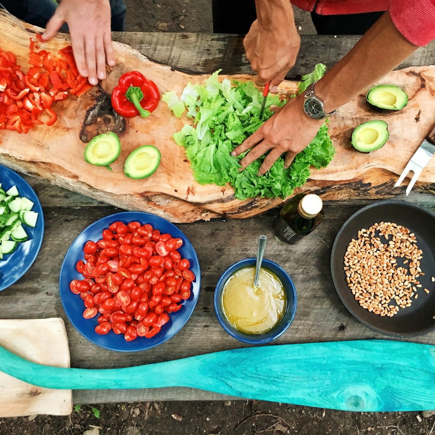 Diverse group of community members sharing a meal together, showcasing the social bonds formed through collaborative cooking